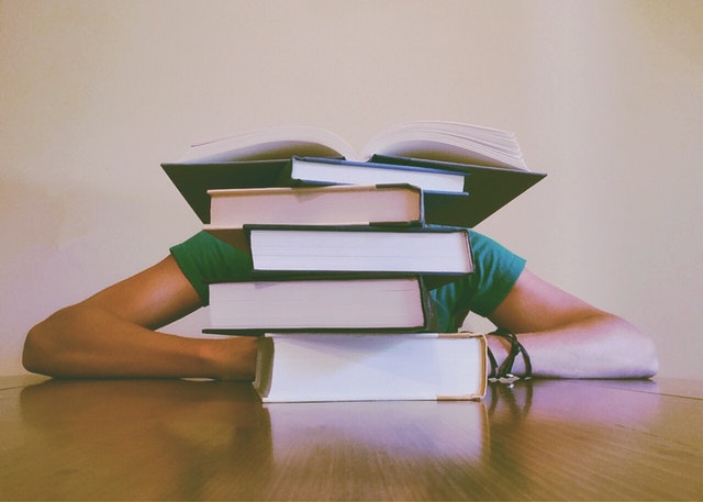 Girl hiding behind books